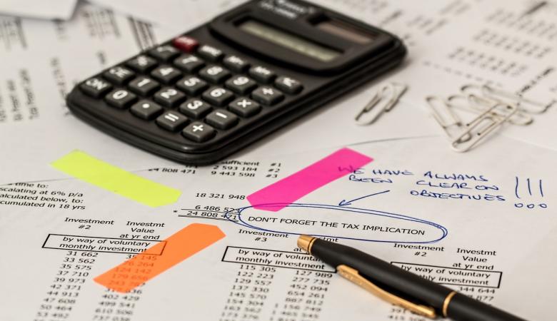 un crayon et une calculatrice posé sur une feuille